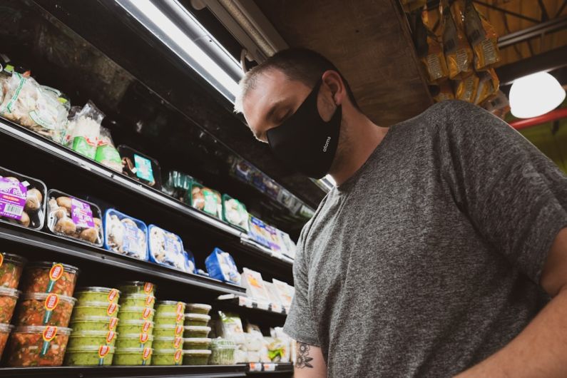 Cheap Groceries - man in gray crew neck t-shirt standing near shelf