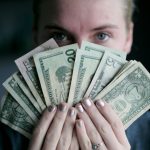 Budget Gift - person holding fan of U.S. dollars banknote