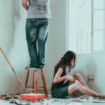 DIY Home - woman in gray tank top and blue denim jeans sitting on bed