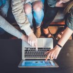 Online Auction - three person pointing the silver laptop computer