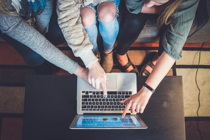 Online Auction - three person pointing the silver laptop computer