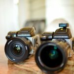 Electronics Favorite - a couple of cameras sitting on top of a wooden table