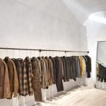 Luxury Discount - a room with a wall of clothes on the wall