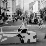 Marketplace Diversity - a woman sitting on a box in the middle of a street