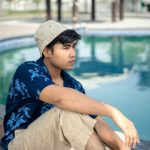 Fashion Collaboration - a man sitting on the edge of a swimming pool