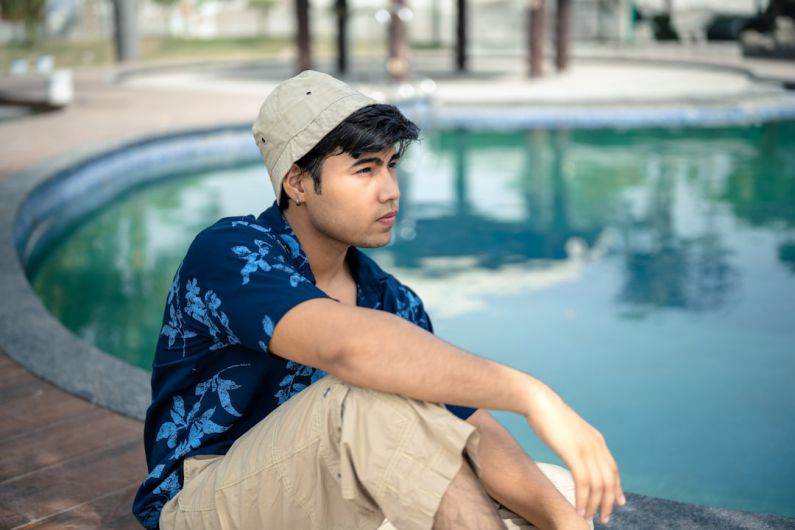 Fashion Collaboration - a man sitting on the edge of a swimming pool