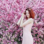 Spring Fashion - woman in white sleeveless dress standing beside pink flowers