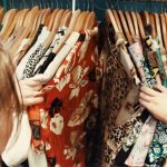 Vintage Fashion - person holding assorted clothes in wooden hanger