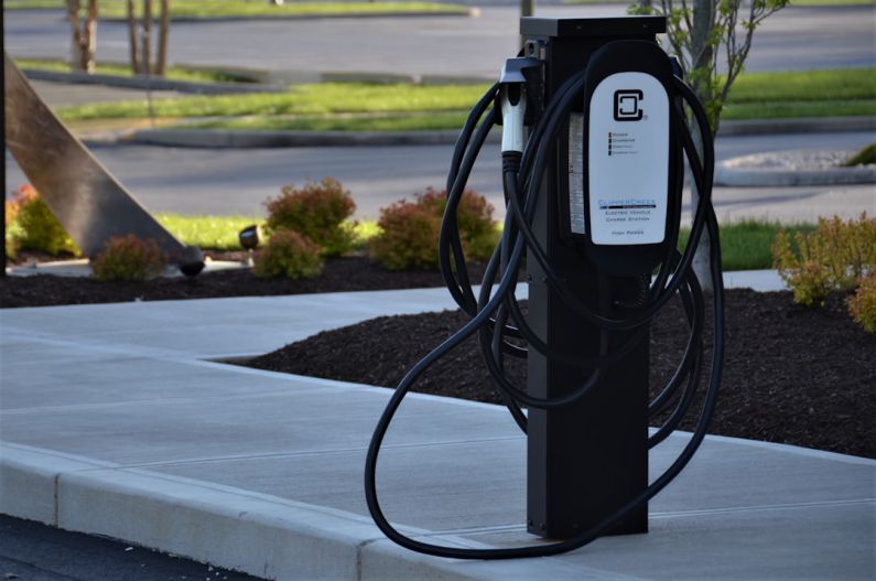 Electric Transport - black metal stand on gray concrete road during daytime