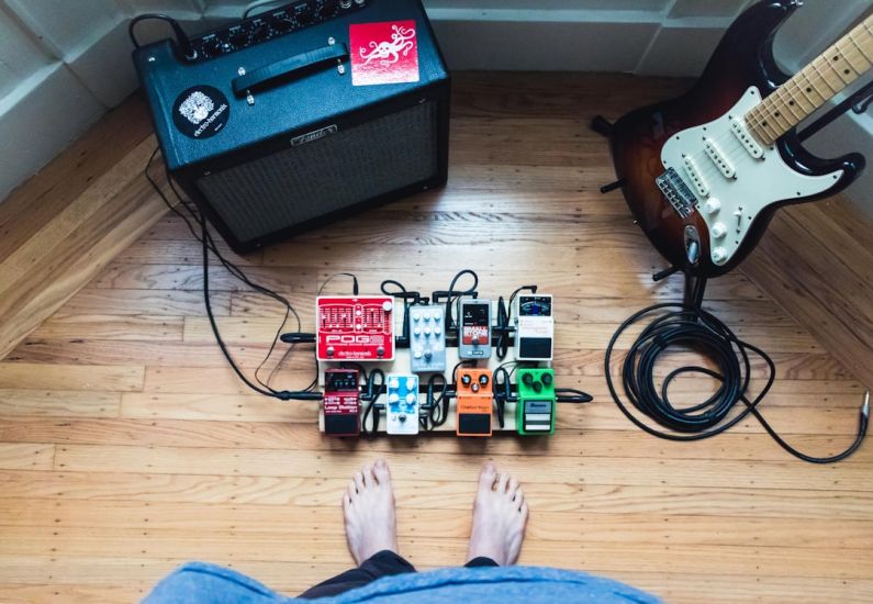 Streaming Device - assorted guitar pedal lot beside electric guitar and amplifie