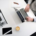 Budget Gift - person using laptop on white wooden table