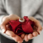 Romantic Gift - person holding red petaled flower and silver-colored ring