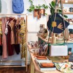 Ethical Fashion - assorted-colored clothes on rack near brown wooden table