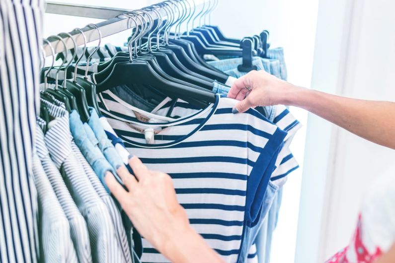 Sustainable Wardrobe - person holding white and black striped shirt